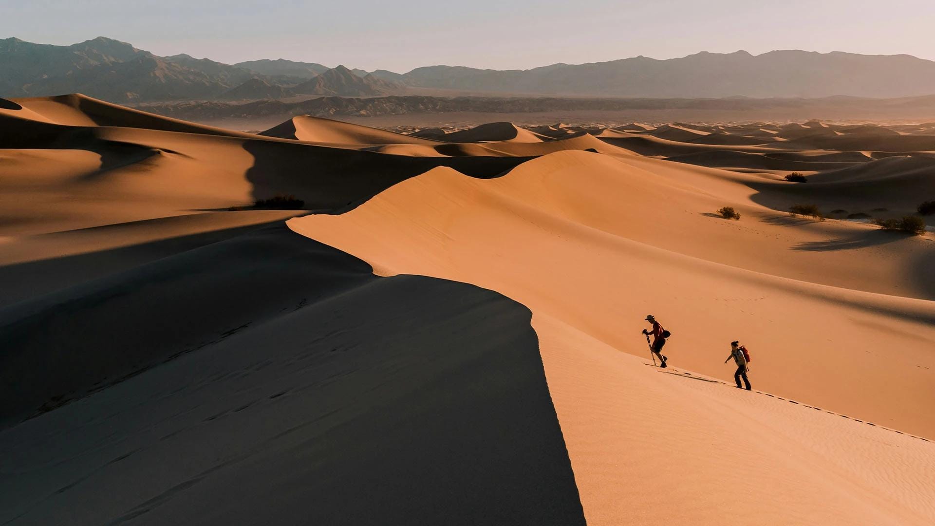 Due persone camminano in un deserto immenso.